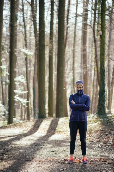 Mujer en forma de pie en el bosque después del entrenamiento —  Fotos de Stock