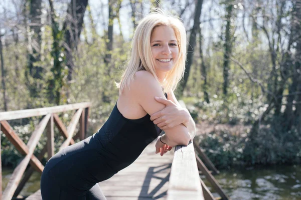 Ontspannen na de training. Zijaanzicht van de mooie jonge vrouw op zoek naar de camera terwijl permanent buiten. — Stockfoto