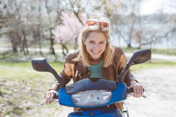 Gelukkig jonge vrouw rijden op scooter — Stockfoto