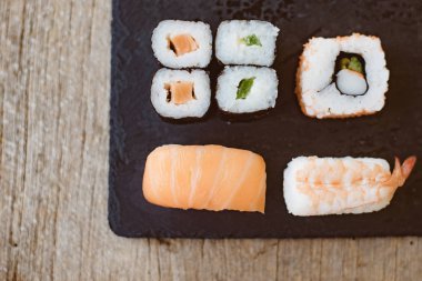 Suşi Sashimi ve suşi ruloları taş levhada servis edilir.