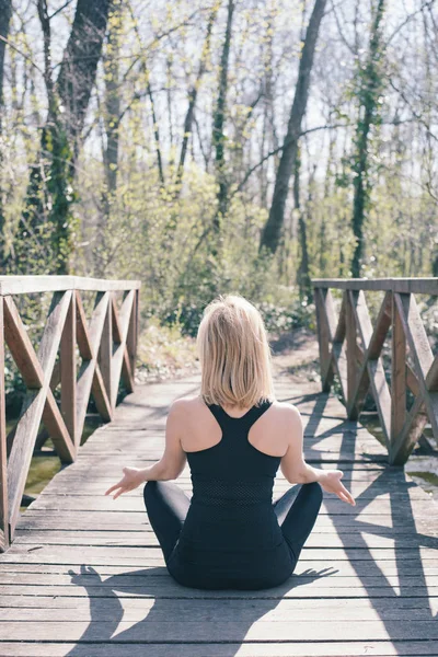 Joven mujer de pelo largo meditando al aire libre —  Fotos de Stock