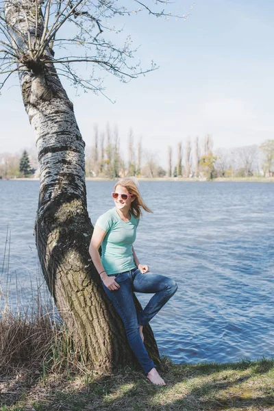 Mujer de vacaciones parada junto a un lago —  Fotos de Stock