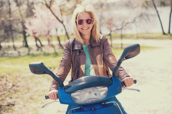 Mujer joven conduciendo scooter o motocicleta —  Fotos de Stock