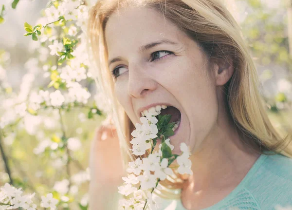 屋外の花を食べるベジタリアンやビーガンの女 — ストック写真