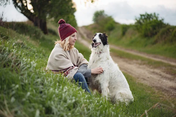Söt ung kvinna vilar utomhus med hennes hund — Stockfoto
