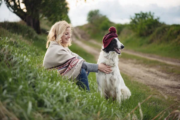 Söt ung kvinna vilar utomhus med hennes hund — Stockfoto