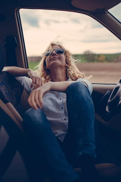 Молода жінка в машині в сонцезахисних окулярах — стокове фото