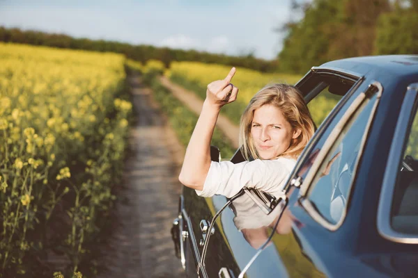 Жінка веде свою машину дуже агресивно і дає жест — стокове фото