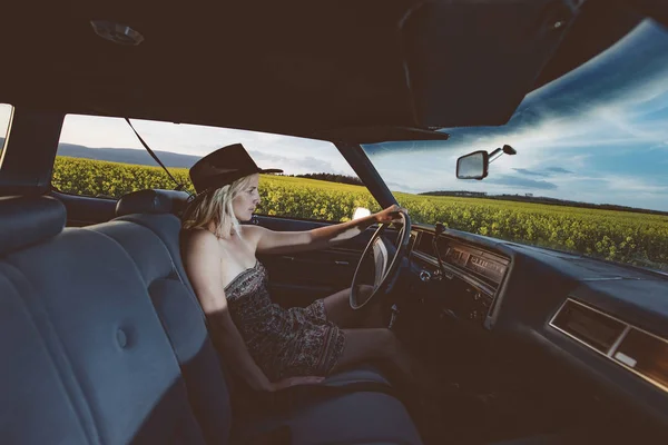Vrouwelijke bestuurder in voertuig interieur. Rijden in de zonsondergang. — Stockfoto