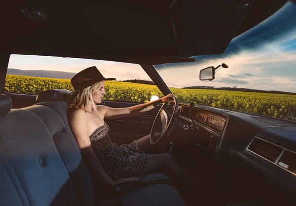 Joven conductora en camino abierto. Mujer conduciendo coche vintage en viaje por carretera . — Foto de Stock