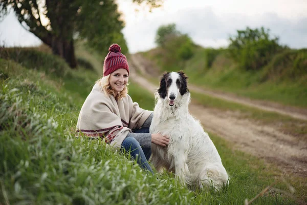 Kvinnan och hennes hund vilar utomhus. — Stockfoto