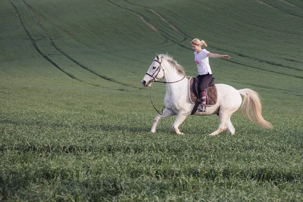 Femme chevauchant à cheval à bras ouverts — Photo