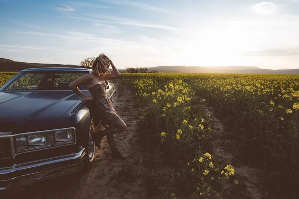 Mulher e carro ao pôr do sol — Fotografia de Stock