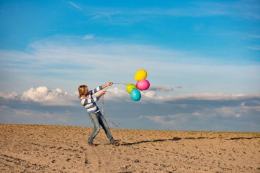 Genç kadın açık balonlarla eğleniyor