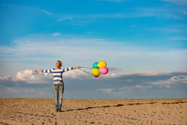 Chica feliz con globos de colores de pie brazos abiertos — Foto de Stock