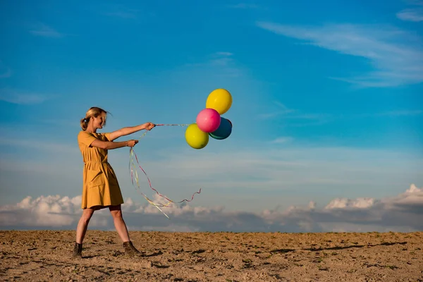 Mujer joven tirando de globos de colores — Foto de Stock