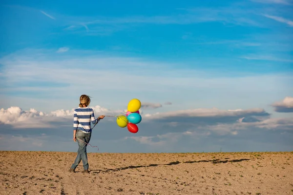 Woman with toy balloons in windy weather