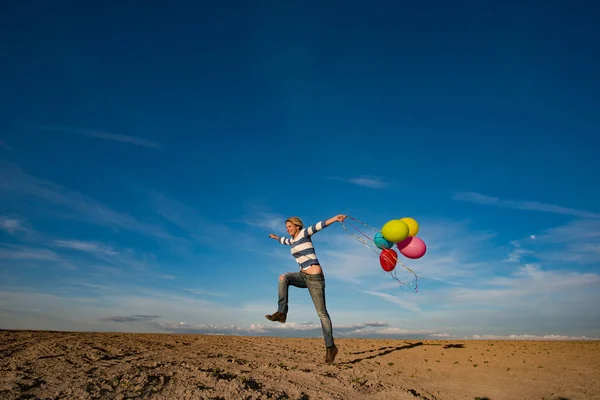 Mutlu kız oyuncak balonlarla açık atlama — Stok fotoğraf