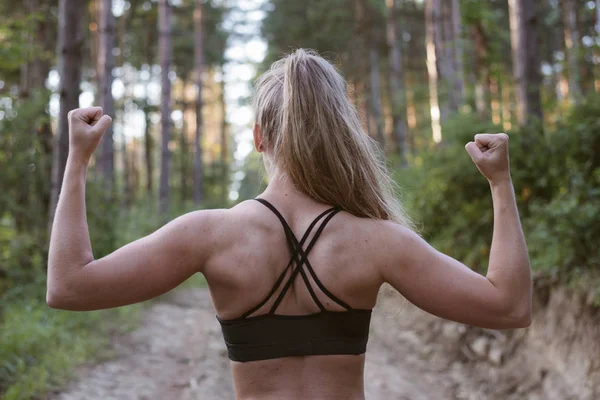 Vista posterior de la musculosa mujer deportiva en el bosque —  Fotos de Stock