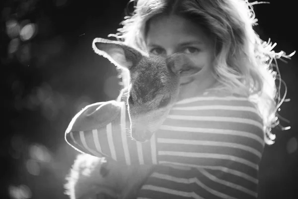 Mooie jongedame dierlijke reeën fawn knuffelen in de zon, bescherming van een dier — Stockfoto