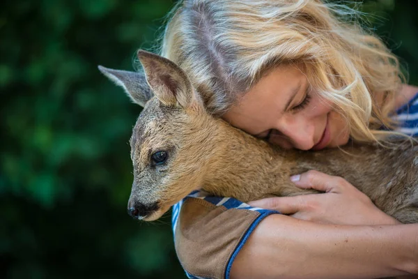 Animal care concept, Young woman taking care of young deer fawn