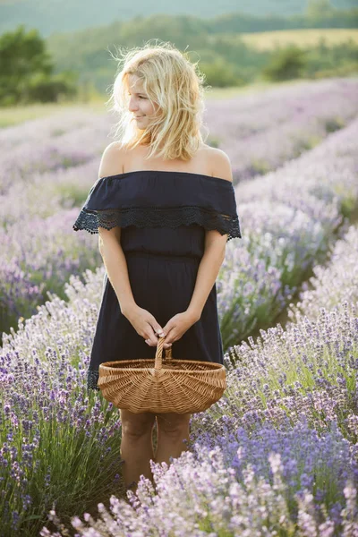篮子里站在薰衣草田地的可爱女人 — 图库照片