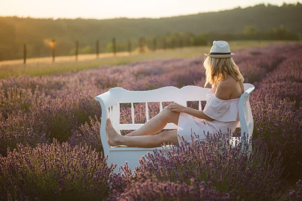 Femme romantique regardant coucher de soleil sur le banc du parc . — Photo