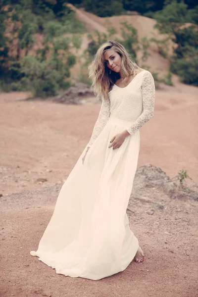 바람이 부는 날씨에 서 있는 신부. 아름 다운 하얀 드레스. — 스톡 사진