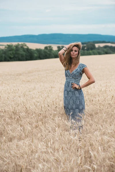 Природний вигляд красива жінка стоїть на пшеничному полі — стокове фото