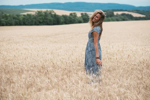 Модна дівчина стоїть на пшеничному полі — стокове фото