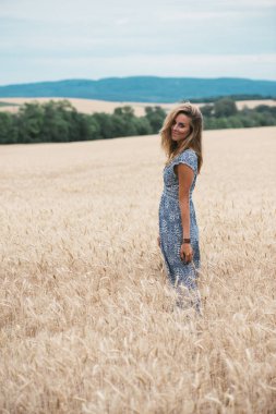 Açık havada duran ve kameraya bakıyor güzel kadın