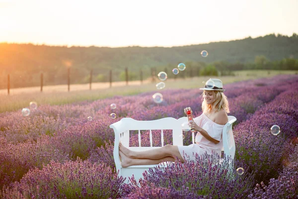 Fiatal nő szappanbuborék fújás. a 20-29 éves nő buborék pálca szabadtéri játék. — Stock Fotó