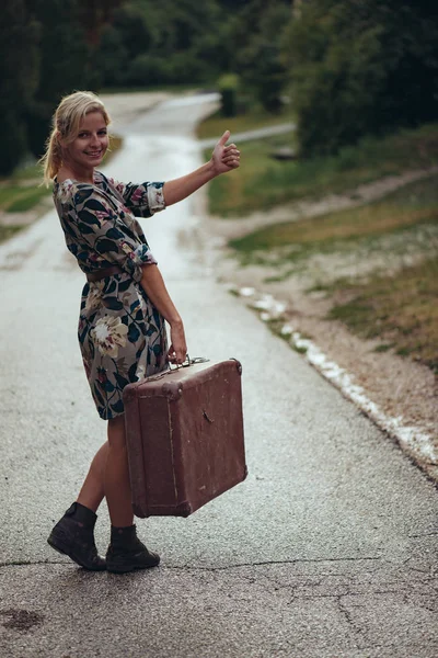 Mujer autoestopista con maleta vintage —  Fotos de Stock