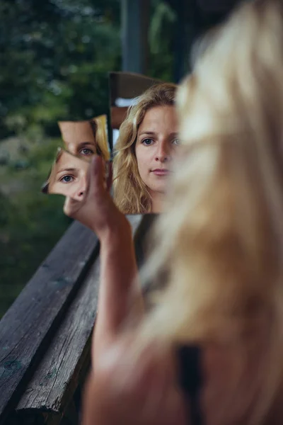 Mujer triste mirando el espejo roto — Foto de Stock