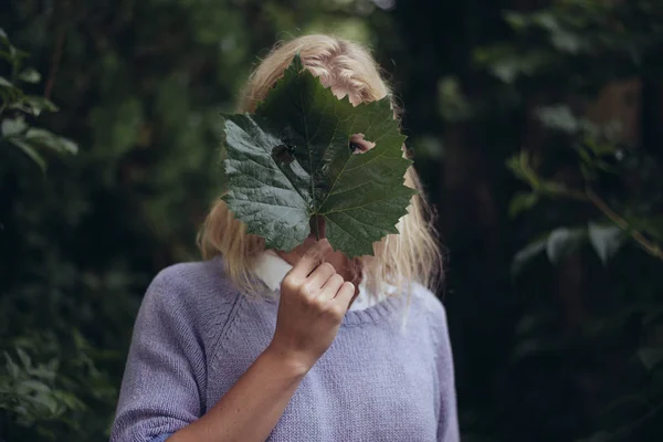 Frau mit frischem Blatt über dem Gesicht — Stockfoto