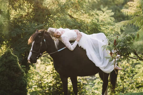 Hermosa mujer en vestido blanco relajante a caballo — Foto de Stock