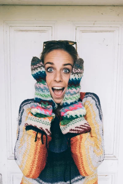 Beautiful woman making facial expression with knitted gloves. — Stock Photo, Image