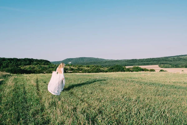 美しい女性を実行しているまたは夏の畑の上を歩く — ストック写真