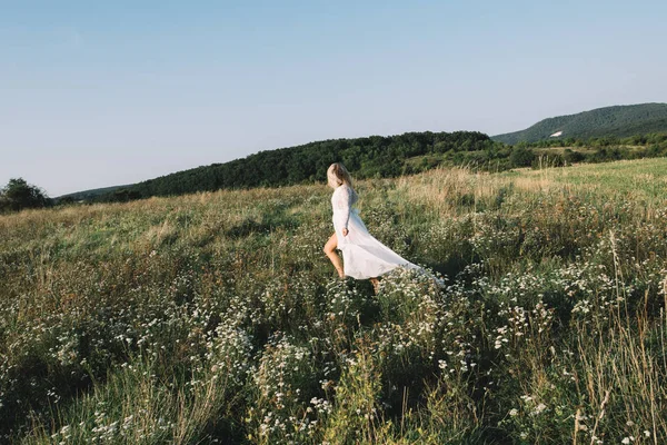 Mulher bonita correndo ou andando no campo de verão — Fotografia de Stock
