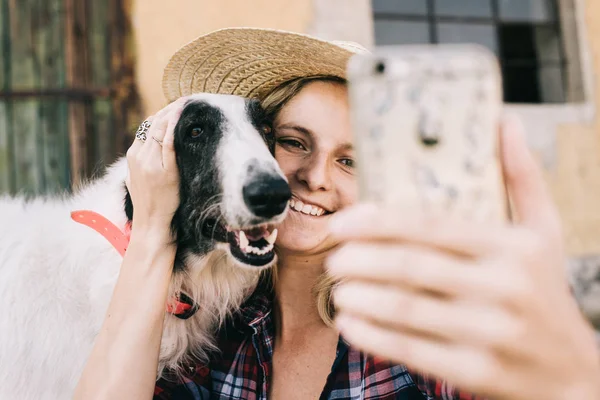 Молода жінка бере власний портрет зі своєю собакою — стокове фото