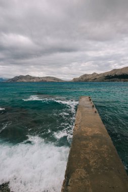Fırtınalı denizde. Sahilde beton İskelesi.