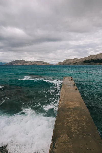 Fırtınalı denizde. Sahilde beton İskelesi.