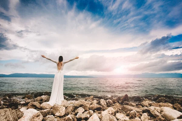 Casamento na praia. Casamento na ilha. Bela noiva de pé de braços abertos. Mulher relaxada desfrutando de sol, liberdade e vida uma bela praia ao pôr do sol. Jovem senhora sentindo-se livre, relaxado e feliz . — Fotografia de Stock