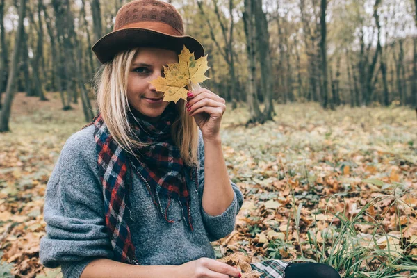 Šťastná žena baví s listy venkovní v lese — Stock fotografie