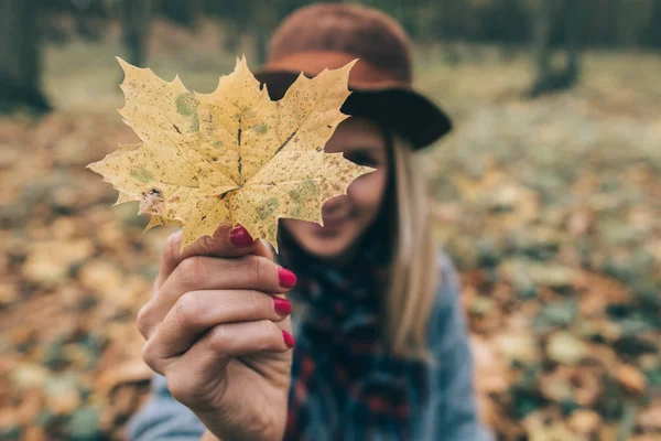 Щаслива жінка розважається з листям, відкритим у лісі — стокове фото