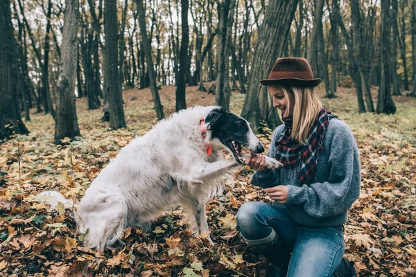 Vrouw speelt met haar hond in het bos — Stockfoto
