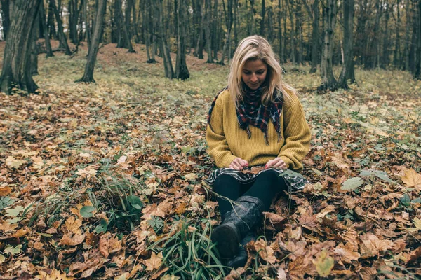 Mladá žena sedící venkovní — Stock fotografie