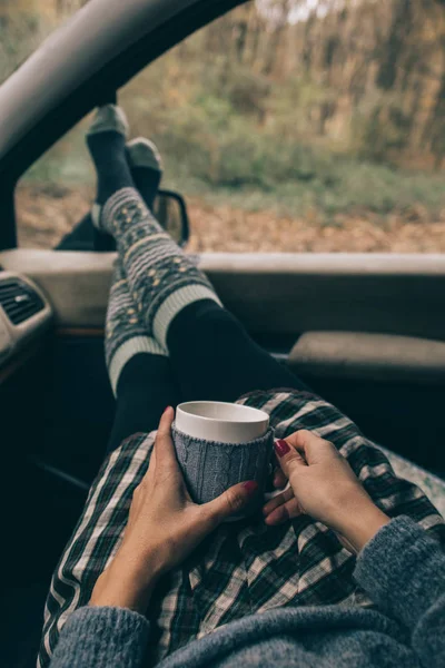 Mujer relajante en el interior del coche con una taza — Foto de Stock