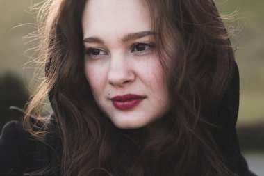 Güzel bir kadın açık, yumuşak güneş ışığı saç ciddi portresi.