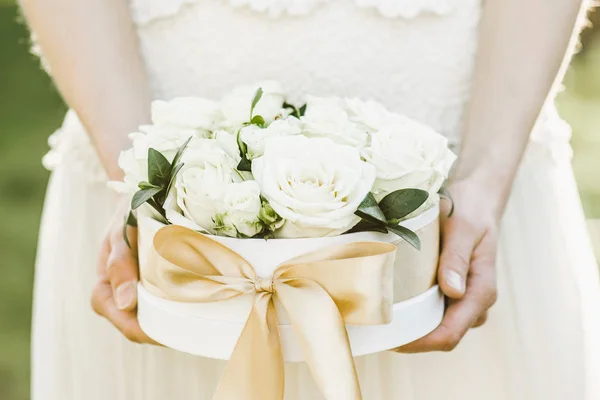 Bridesmaid holding a box of roses. Rose box. Beautiful gift with white roses.